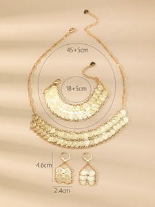 Detail of 24k gold-plated jewelry set with overlapping scale texture and coin patterns