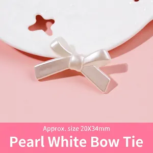 Macro shot of 20x34mm pearl white resin bowknot bead with soft luster on a decorative tray