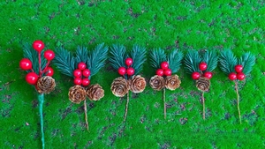 Detail of artificial pine branches with red berries and natural cones for Christmas DIY