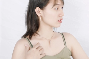 Close-up of rose gold conical necklace and earrings set on a female model