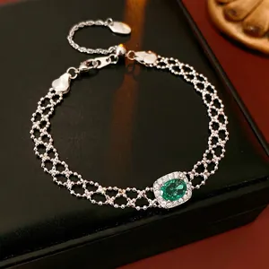 Vintage silver mesh bracelet with an oval green zircon and a halo of small white crystals