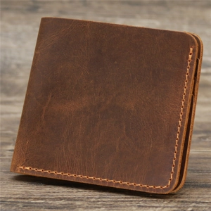 Retro brown short wallet in crazy horse leather with handmade stitching on wooden surface