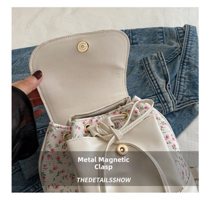 Detail of floral PU leather backpack featuring magnetic metal buckle and drawstring closure