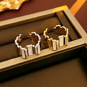 Detail of gold and silver irregular rings with shell inlay and pavé zircon in a jewelry box
