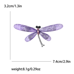 Fashionable purple dragonfly brooch with pink crystals and silver metal base on white background