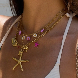 Gold ocean theme layered necklace with starfish and shell pendants on a model