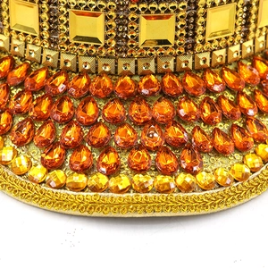 Luxurious gold festival hat with orange teardrop crystals and sparkling rhinestones