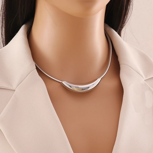 Polished silver geometric stainless steel choker necklace on model in beige blazer