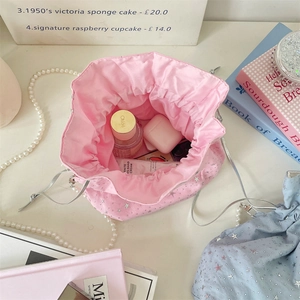 Detailed top view of pink drawstring canvas bag showing storage for personal items