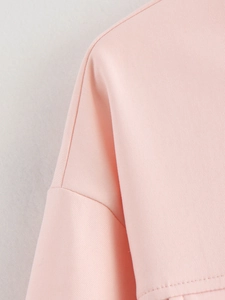 Gros plan de la couture d'épaule et texture du tissu sur une veste de baseball rose