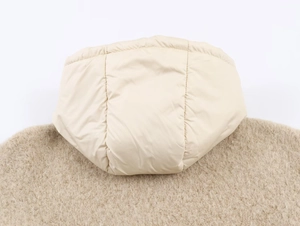 Détail d'une doudoune beige à capuche montrant la texture matelassée et le tissu doux