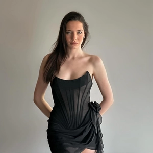 Detail of a black tube dress featuring sheer mesh panels and 3D floral waist decorations