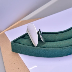 Macro view of minimalist silver curved metal sheets showing polished mirror finish and texture