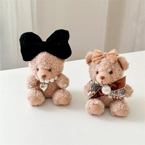 Detailed view of plush bear pendants with velvet bows, pearls and heart charms