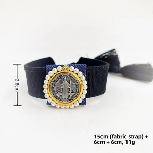 Detail of handwoven Saint Benedict medal bracelet with 18k copper beads and white faux pearls