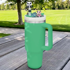 Green 40oz stainless steel tumbler with panda straw cover on a wooden park table