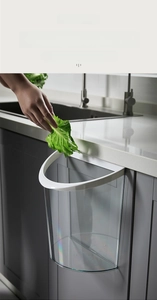 Wall-mounted transparent kitchen trash can showing easy installation on cabinet doors