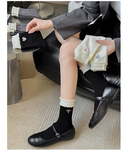 Detailed view of sweet women ruffle cuff mid-tube socks with cute heart bow embroidery details.