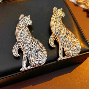 Nahaufnahme von goldenen und silbernen Katzenbroschen im Vintage-Stil auf Lederhintergrund