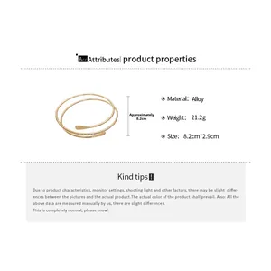 Detail of golden multi-layered open bangle with hammer finish and spiral alloy design