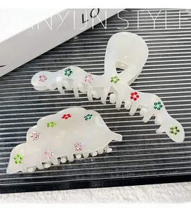 Detail of pearlescent acetate hair claws with colorful rhinestone floral patterns