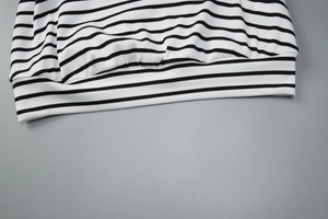 Close-up of the black and white striped knit top showing the ribbed hem and fabric texture