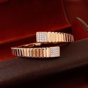 Close-up of rose gold ribbed bangle with square pavé zircon ends in a premium gift box