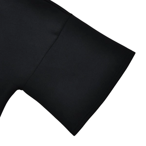 Detailed close-up of smooth black fabric short sleeve cuff with precision stitching