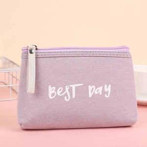 Detail of purple canvas cosmetic bag with BEST DAY lettering and white leather handle strap