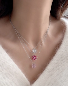 Detail shot of triple-layered S925 silver necklaces with tri-color floral pendants