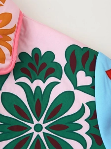 Detailed macro view of colorful floral pattern and woven texture on a women's padded jacket