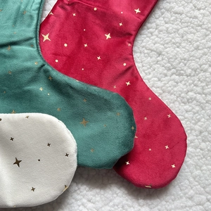 Close-up of velvet Christmas stockings with gold star embroidery in red, green and white