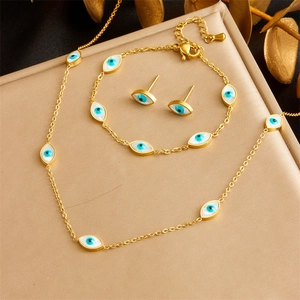 Golden Evil Eye jewelry set including necklace bracelet and earrings on elegant background
