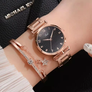 Close-up of rose gold watch and star-pendant bracelet set on luxury leather background