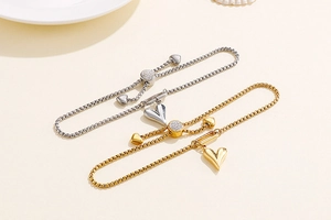 Detail of adjustable heart bracelets with gold and silver finish and pavé cubic zirconia