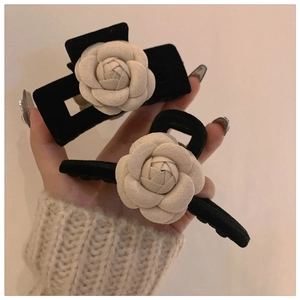 Close-up of elegant black velvet hair claw clip with a 3D white camellia flower