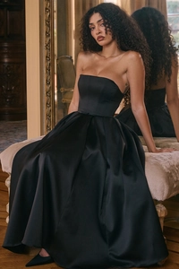 Close-up of elegant black strapless satin gown with a voluminous pleated skirt