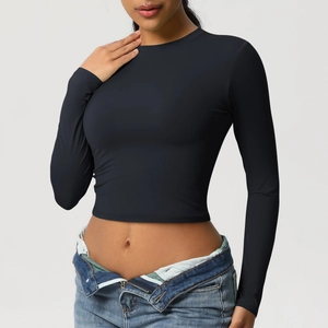 Gros plan du crop top noir à manches longues soulignant sa coupe ajustée et son tissu
