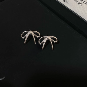 Gros plan de boucles d'oreilles nœuds en argent poli sur une boîte à bijoux noire