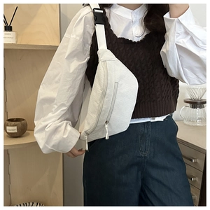 Close-up of white corduroy crossbody bag featuring adjustable strap and dual zippers