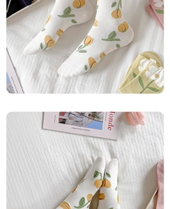 Dettaglio di calze in cotone bianco con stampa di tulipani gialli e foglie verdi