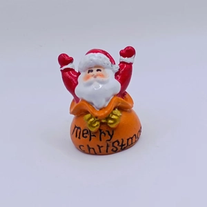 Close-up of resin Santa Claus figurine with Merry Christmas lettering for holiday decor
