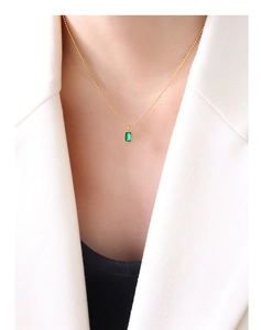 Detail of emerald zircon pendant on 18K gold plated beaded chain worn on collarbone