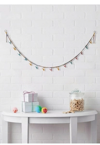 Colorful woven cotton storage rope with multi-colored clips hanging on a white wall