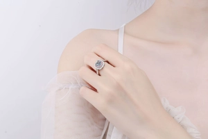 Detail of S925 silver halo ring featuring pink and white stones on female hand