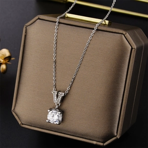 Silver V-shape zircon pendant necklace on a luxury brown textured jewelry box