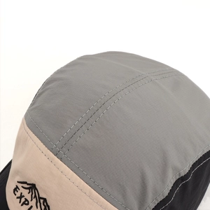 Close-up of color-block five-panel hat with mountain embroidery and ripstop texture