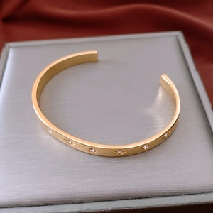 Close-up of 18K gold-plated cuff bracelet with starburst engraving and zircon inlays