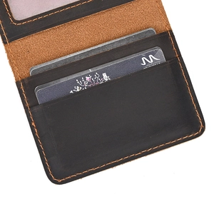Detail of dark brown leather wallet interior showing card slots and contrast stitching