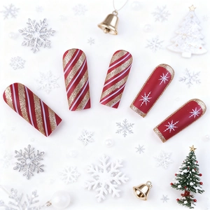 Christmas press-on nails with red matte base, gold glitter stripes and white snowflakes
